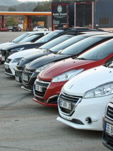 pexels-photo-28928971-28928971 Lineup of modern cars neatly parked outdoors at a dealership with visible license plates.